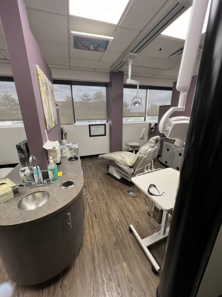 Modern dental treatment room at Belleview Dental with reclining chair, dental equipment, and large windows for natural light.