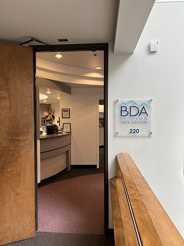 Entrance to Belleview Dental Associates office, suite 220, featuring the BDA sign and reception desk inside.