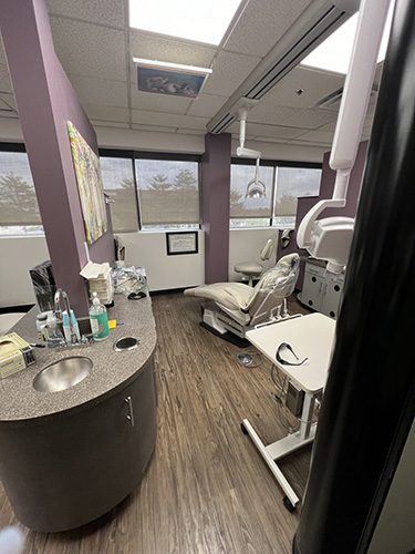 Modern dental treatment room at Belleview Dental with reclining chair, dental equipment, and large windows for natural light.